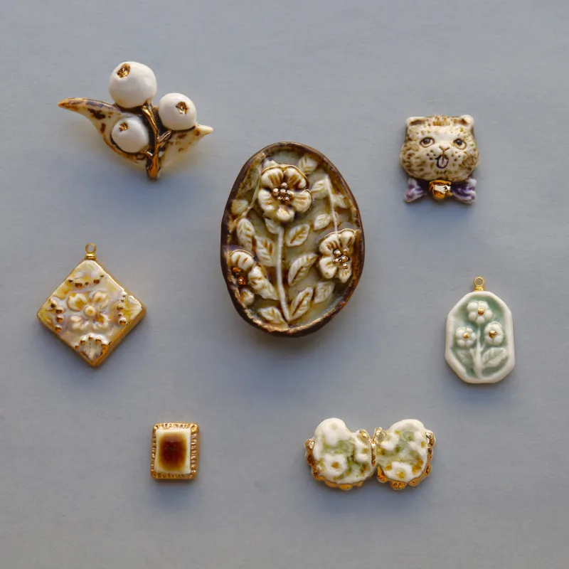 陶器で作られた花のレリーフが彫り込まれたブローチ。（写真中央）