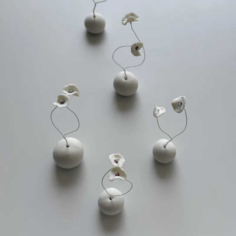白磁の花のオブジェ。
茎にはワイヤーが入っているのでお好きな形に曲げてお愉しみください。